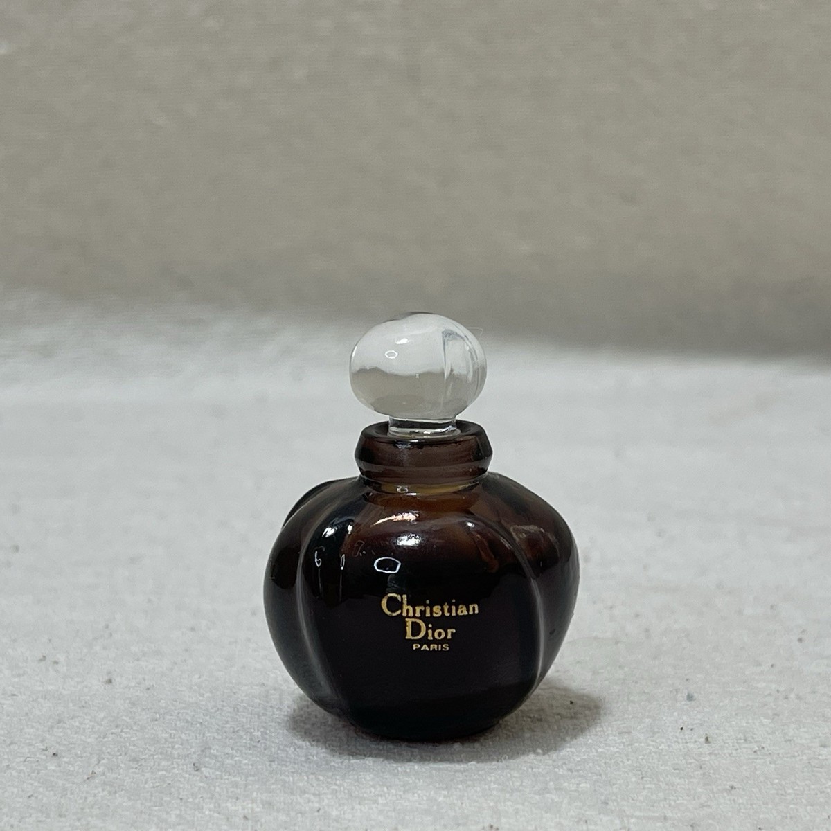 Miniature de parfum Poison de Christian Dior sur fond blanc
